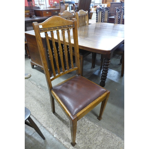 176 - An early 20th century oak extending dining table and four chairs.