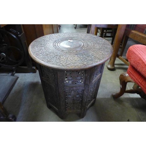 183 - An Indian carved hardwood folding occasional table