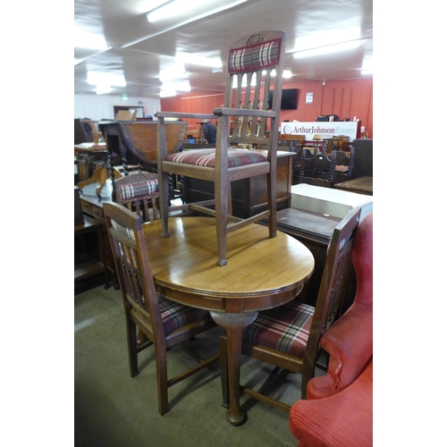 184 - An oval oak dining table and four Arts and Crafts oak chairs