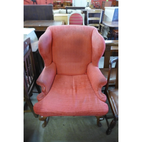 185 - An early 20th Century Queen Anne style walnut and fabric upholstered wingback armchair