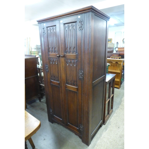 200 - A carved oak linenfold wardrobe