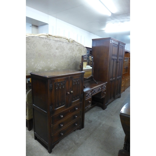 201 - A carved oak linenfold four piece bedroom suite