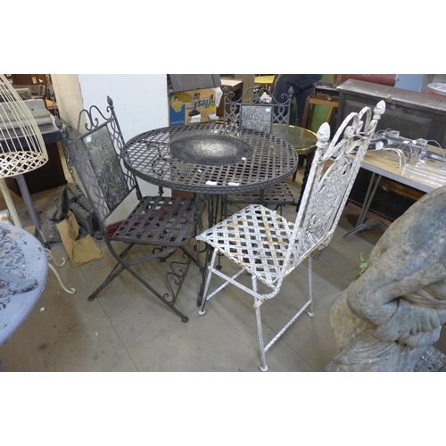 275 - A wrought steel garden table and three folding chairs