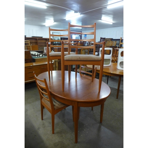 28 - A teak extending dining table and four chairs