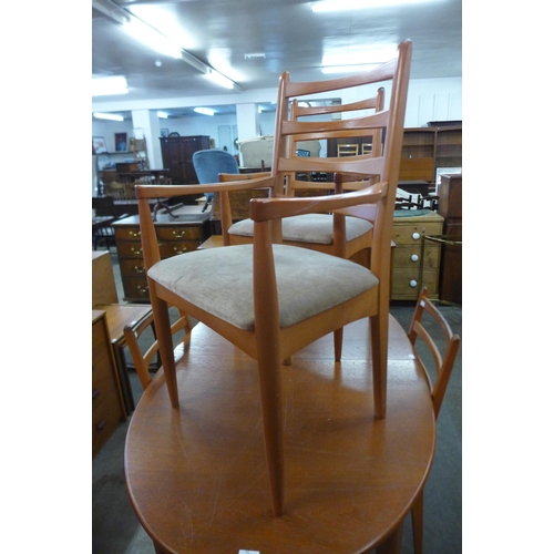 28 - A teak extending dining table and four chairs