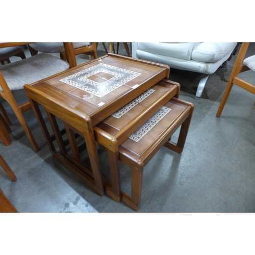 31 - A teak and tiled top nest of tables