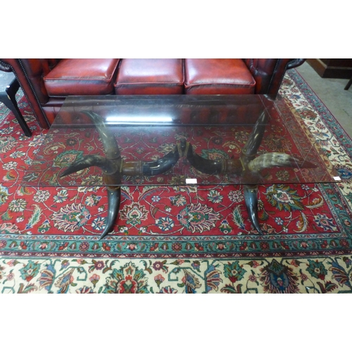 54 - An eastern cow horn based and smoked glass topped coffee table