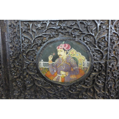 68 - An Indian carved hardwood four panel folding screen, inset with hand painted Mughal school gouaches