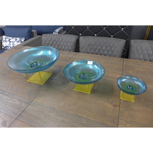 1329 - A set of three blue dishes on gold stands