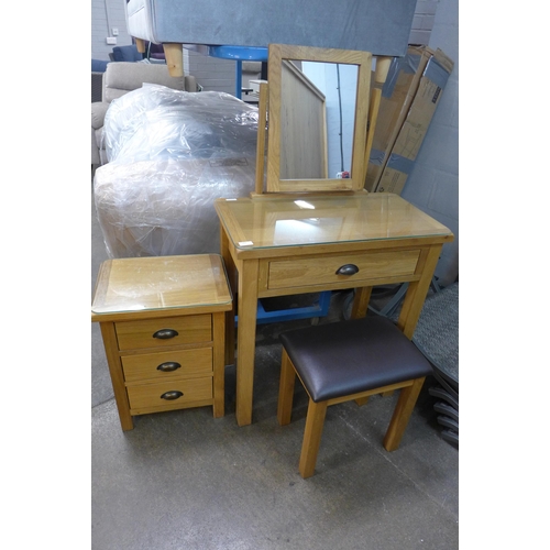 1409 - An oak dressing table with stool and a three drawer bedside chest