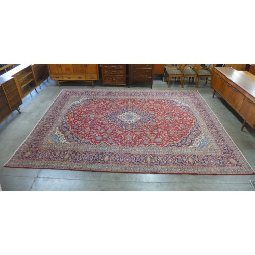 140 - A Persian red ground rug, 398 x 300cms