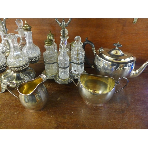 707 - Two six-bottle cruets with plated stands and a silver plated three piece tea service