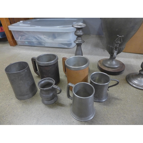 823 - A collection of pewter tankards, a pair of pewter candlesticks, a large urn and a jug