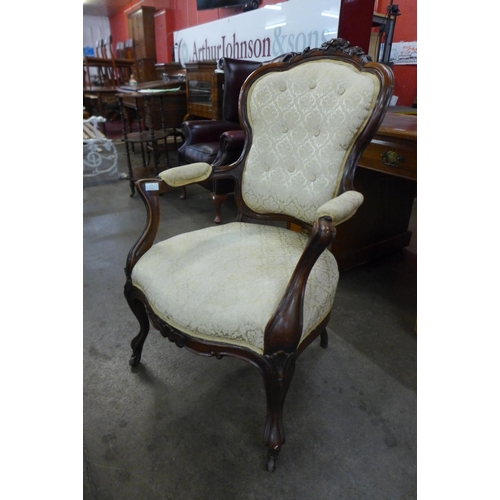 11 - A Victorian carved walnut and fabric upholstered open armchair