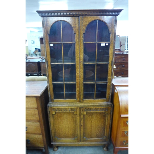 131 - An early 20th Century carved oak four door bookcase