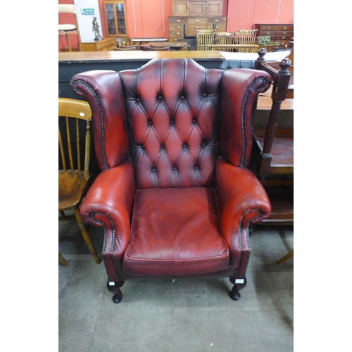 150 - A red leather Chesterfield wingback armchair