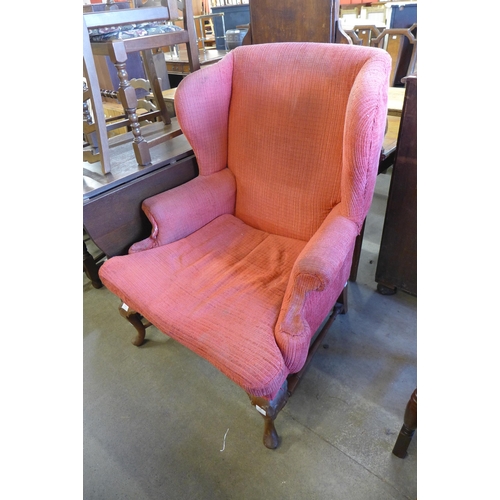 229 - An early 20th Century Queen Anne style walnut and fabric upholstered wingback armchair