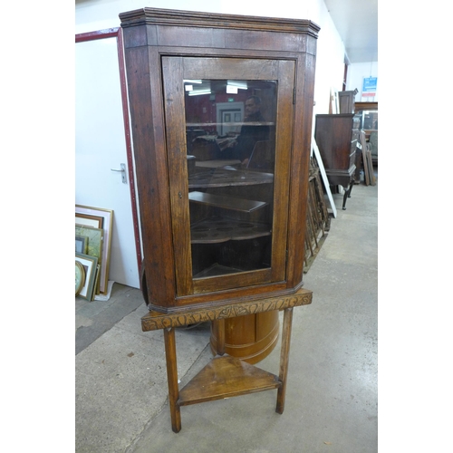 269 - A George III oak splay front corner cabinet on later associated stand