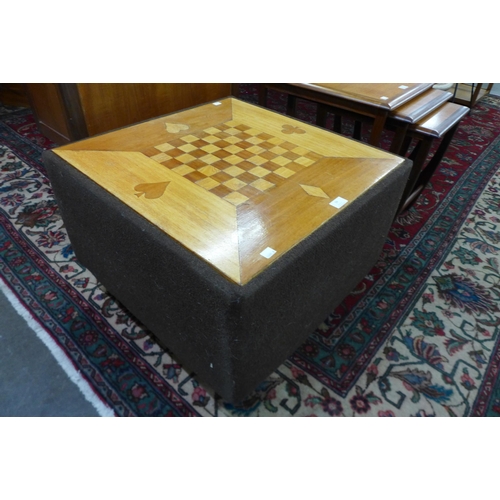 59 - An inlaid teak and upholstered games table/ottoman