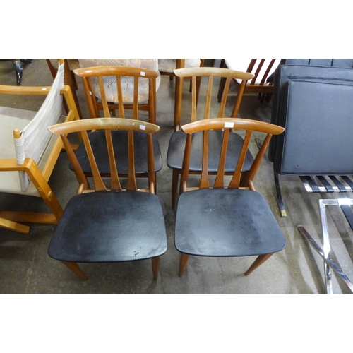 83 - A set of four Elliotts of Newbury teak and black vinyl dining chairs