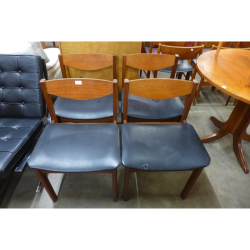 86 - A set of four teak and black vinyl dining chairs