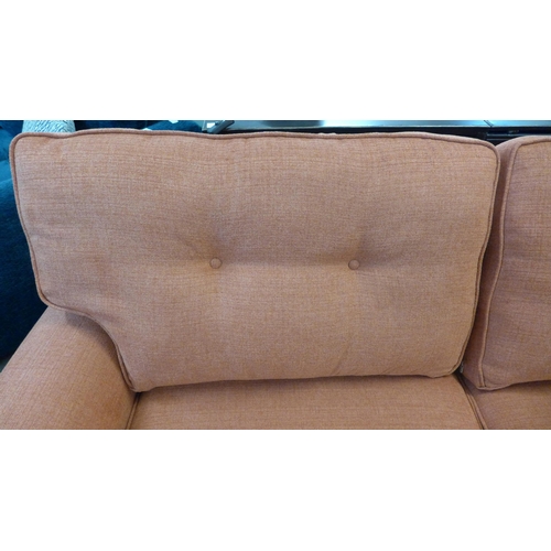 1301 - A burnt orange upholstered three seater sofa