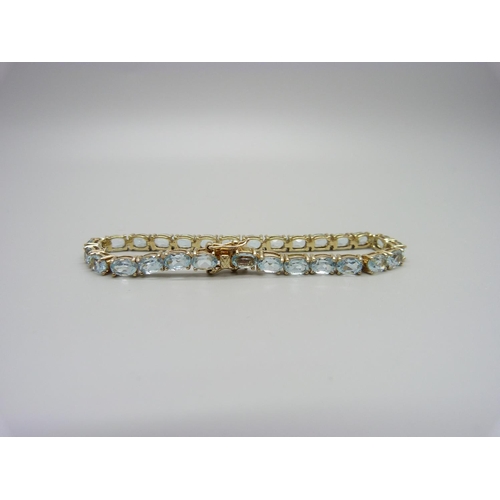 1082 - A silver gilt and topaz tennis bracelet