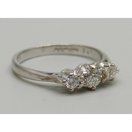 1124 - An 18ct white gold three stone diamond ring, 2.4g, J