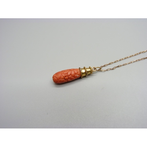 1133 - A carved coral pendant on a yellow metal chain