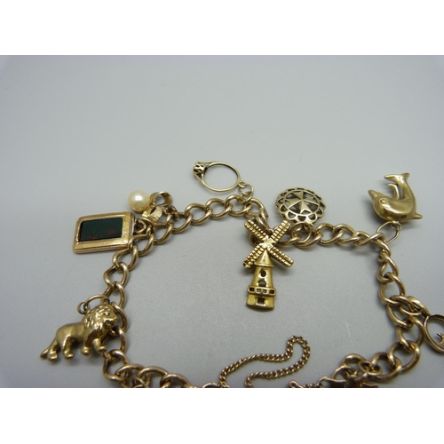 1146 - A 9ct gold charm bracelet with 9ct and yellow metal charms, total weight 22.6g