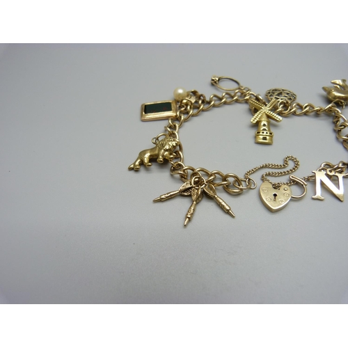 1146 - A 9ct gold charm bracelet with 9ct and yellow metal charms, total weight 22.6g