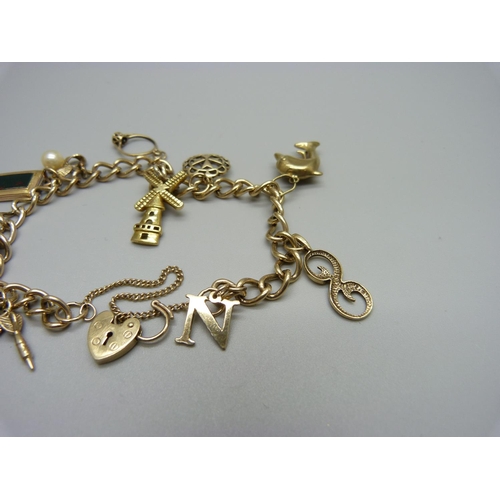 1146 - A 9ct gold charm bracelet with 9ct and yellow metal charms, total weight 22.6g