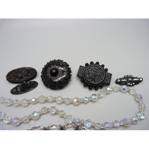 1172 - Three jet brooches, one set with mother of pearl, lacking pin, and three vintage glass bead necklace... 