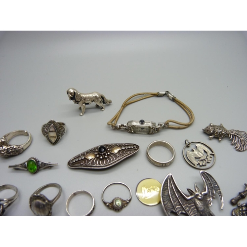 1199 - A silver skull ring, other rings, a hallmarked silver dog figure, 25g, a silver bat brooch, a silver... 