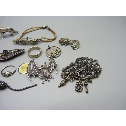 1199 - A silver skull ring, other rings, a hallmarked silver dog figure, 25g, a silver bat brooch, a silver... 