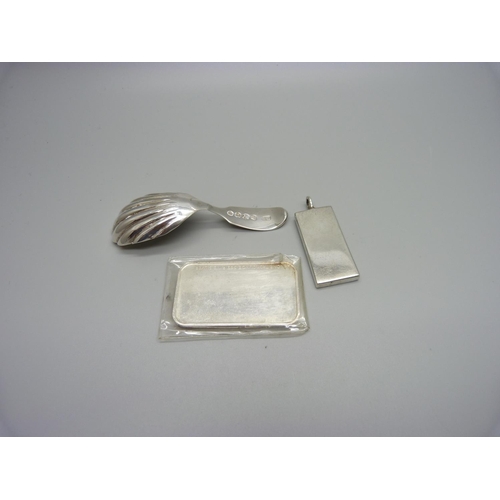 1200 - A silver ingot pendant, one other silver ingot and a silver caddy spoon hallmarked London 1935 and w... 