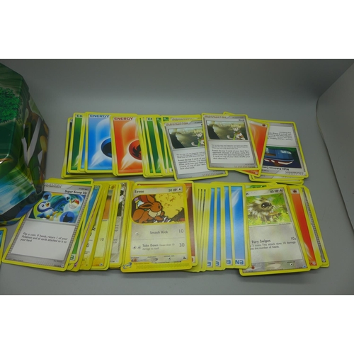 643 - 140 Pokemon cards including, Skyridge set, Neo Genesis set and Hidden Legends set in collectors tin