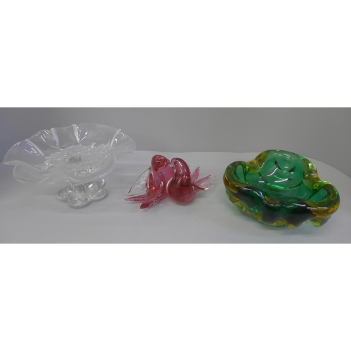 679 - A heavy coloured glass ashtray, glass bird ornament and glass comport