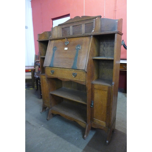 106 - A Liberty & Co. style Arts and Crafts oak bureau bookcase