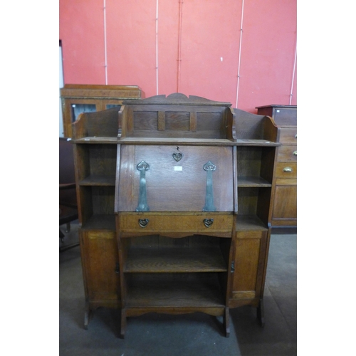 106 - A Liberty & Co. style Arts and Crafts oak bureau bookcase