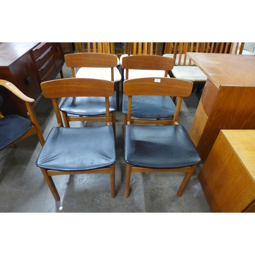 44 - A set of four teak and black vinyl dining chairs