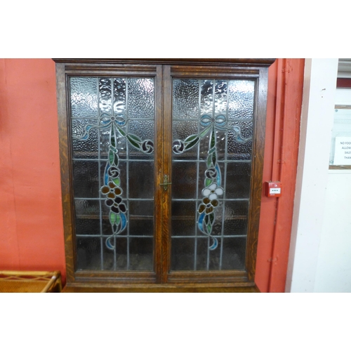 63 - An Edward VII oak and stained glass two door bookcase