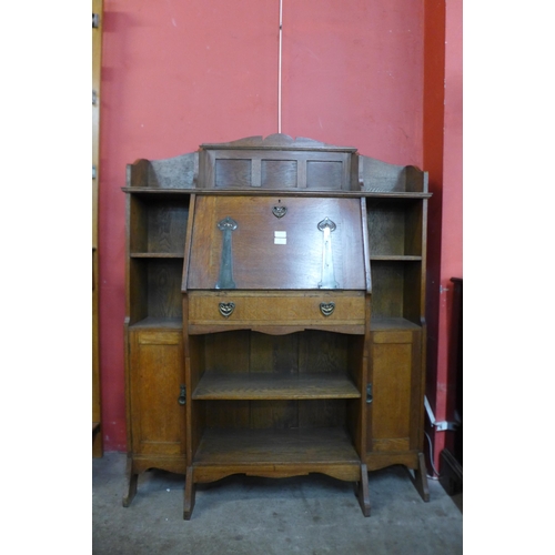 73 - A Liberty & Co. style Arts and Crafts oak bureau bookcase