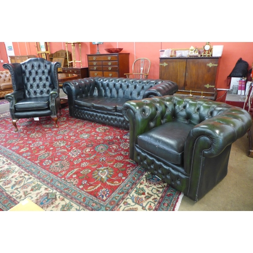 83 - A green leather Chesterfield three piece suite, comprising wingback armchair, club chair and a three... 