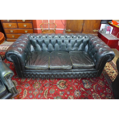 83 - A green leather Chesterfield three piece suite, comprising wingback armchair, club chair and a three... 