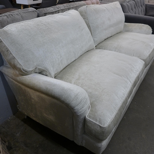 1439 - An ivory velvet three seater sofa on hardwood legs