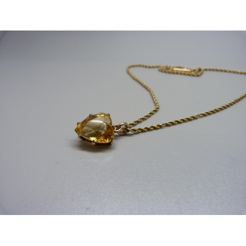 1100 - A 9ct gold and citrine pendant on a yellow metal chain, total weight 7.4g