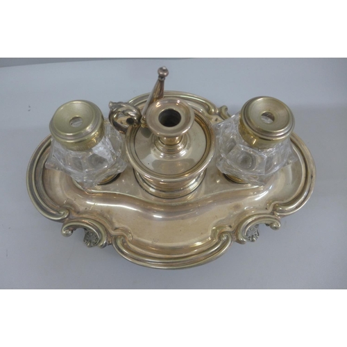 618 - A silver plated ink stand with two glass  inkwells and a small chamber stick, with engraving dated 1... 