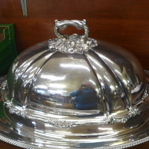 659 - A silver plated meat dome with armorial crest, an associated large tray and spoon