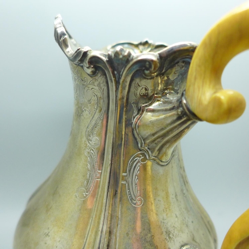 700 - A 19th century continental white metal jug with ivory handle. This lot is offered for sale with non-... 